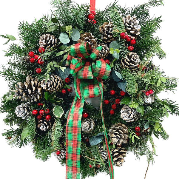 Christmas wreath arrangement with ilex and cones